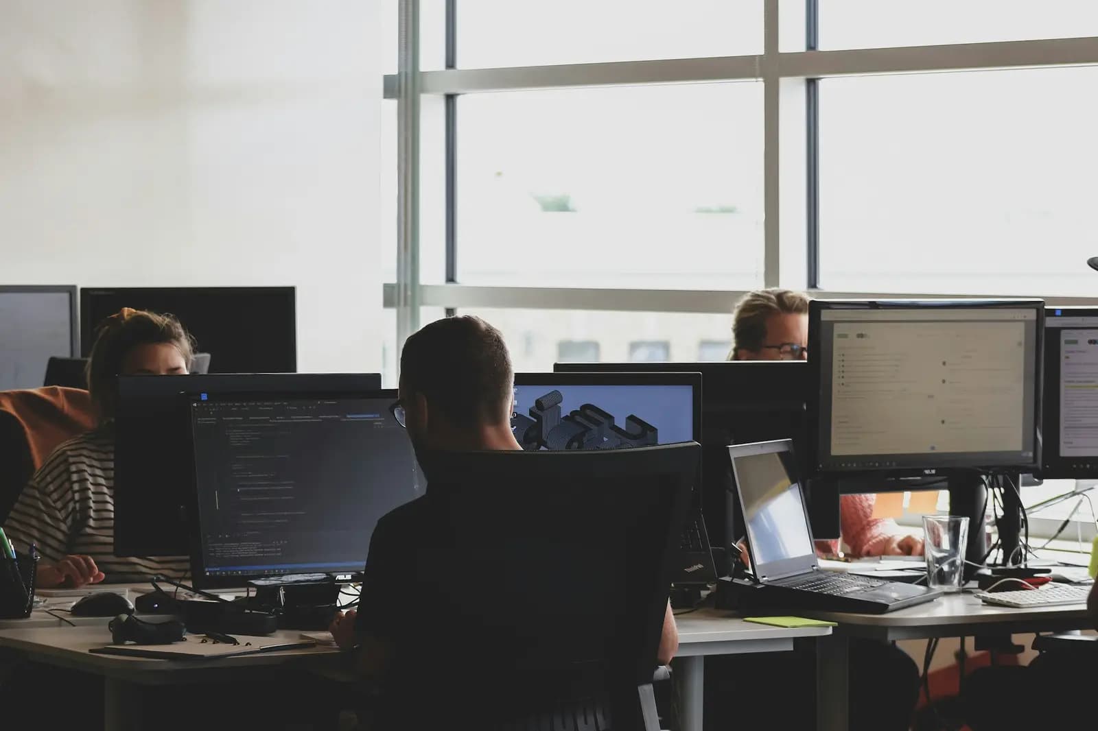 People at work across several screens, each running a different application